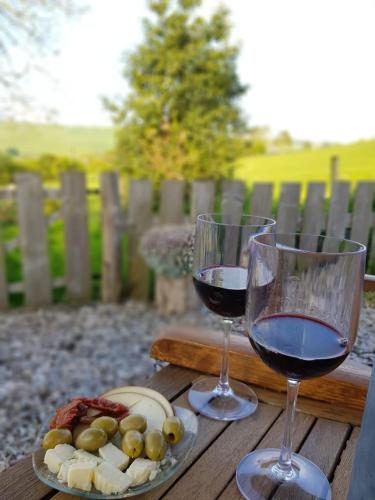 two glasses of wine and a plate of food on a table at Beavers Lodge on top of the Shropshire hills in Craven Arms