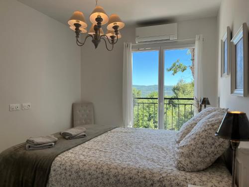 a bedroom with a bed and a large window at Villa Fautea Verdon in Sainte-Croix-de-Verdon