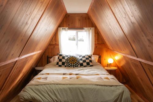 a bedroom with a bed in a room with a window at The Cozy Owl A-Frame in Jefferson