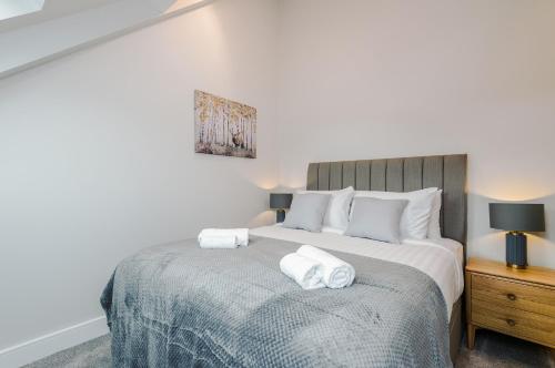 a bedroom with a bed with two towels on it at Rock Mill - 2-Bedroom Duplex Apartments in Stony Middleton