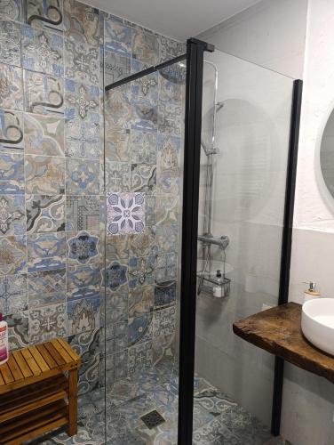a bathroom with a glass shower with a sink at Canto del DORMILERO in San Cristóbal de la Vega