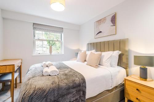 a bedroom with a bed with two stuffed animals on it at Rock Mill - 2-Bedroom Duplex Apartments in Stony Middleton