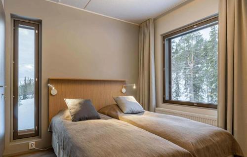 a bedroom with two beds and a large window at Ylläs Chalets IV 4309 in Ylläsjärvi