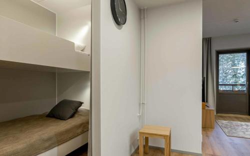 a bedroom with a bed and a clock on a wall at Ylläs Chalets IV 4309 in Ylläsjärvi