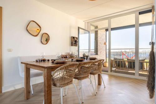 a dining room with a wooden table and chairs at Hello Zeeland - Port Scaldis 11-031 in Breskens