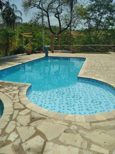 a swimming pool with blue water in a yard at Chácara Cristo Rei in Senador Canedo