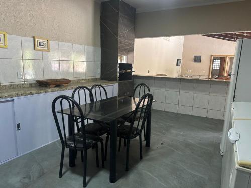 a dining room with a table and chairs in a kitchen at Chácara Cristo Rei in Senador Canedo