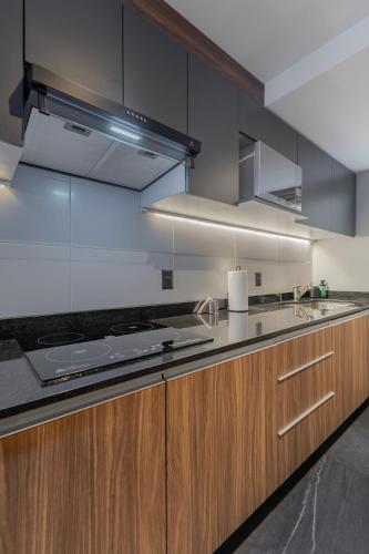 a kitchen with wooden cabinets and stainless steel appliances at Capitalia Obelisk Polanco in Mexico City