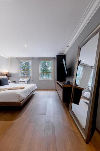 a bedroom with a bed and a large mirror at Capitalia Obelisk Polanco in Mexico City