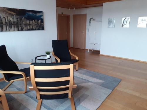 a room with chairs and a table and a painting at Gästewohnung in Parkstetten bei Straubing in Parkstetten