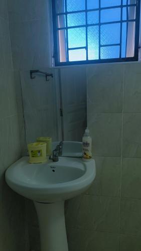 a white sink in a bathroom with a window at NyaliHomes in Mombasa