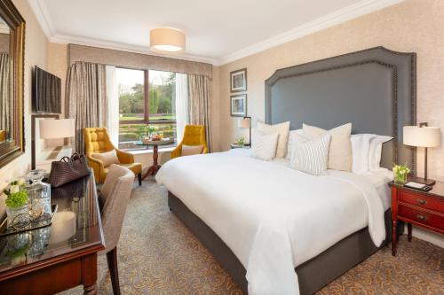 a bedroom with a large bed and a living room at St Helens Hotel, Dublin in Stillorgan