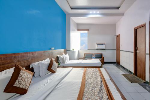a bedroom with two beds and a blue wall at Hotel New Royal Just Near Old Delhi Railway Station And Red Fort in New Delhi