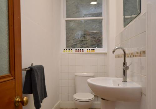 a bathroom with a sink and a toilet and a window at Secret Coast Getaway in Tighnabruaich