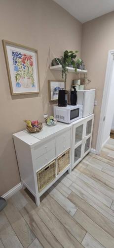 a white cabinet with a microwave on top of it at Lawson Lodge in Alveston