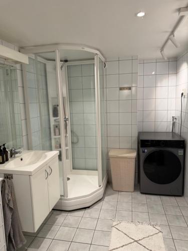 a bathroom with a shower and a washing machine at Leilighet i Kristiansand in Kristiansand