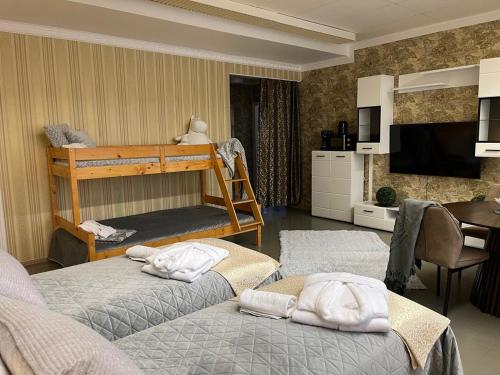 a bedroom with two bunk beds and a kitchen at Hotel Ilomantsi North Star in Ilomantsi