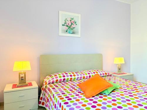 a bedroom with a colorful bed with two lamps at Casa Zoe in Gallipoli