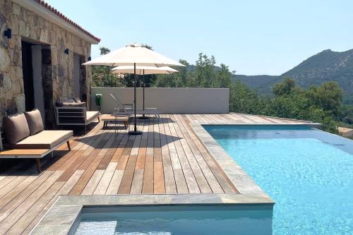 a swimming pool with an umbrella and a wooden deck at Villa Concarella Di Conca in Conca