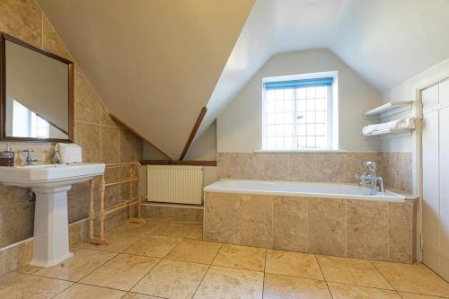 a bathroom with a sink and a bath tub at Huckleberry Farm House in Basildon