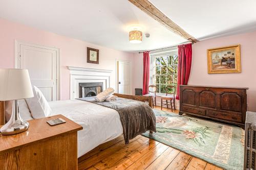 a bedroom with a large bed and a fireplace at Huckleberry Farm House in Basildon