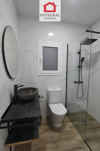 a bathroom with a toilet and a sink and a mirror at Apartament Marea Alta in San Juan de Palamós
