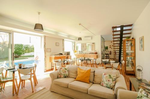 a living room with a couch and a dining room at Pé na Areia - Guest House in Vila Real de Santo António