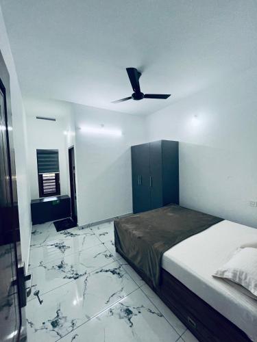 ein Schlafzimmer mit Bett und Deckenventilator in der Unterkunft Stay loop in Cherambādi