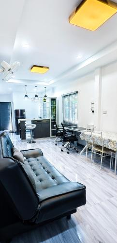 a living room with a black couch in the middle at The Engineer's Villas, Krabi in Ban Khlong Chi Lat