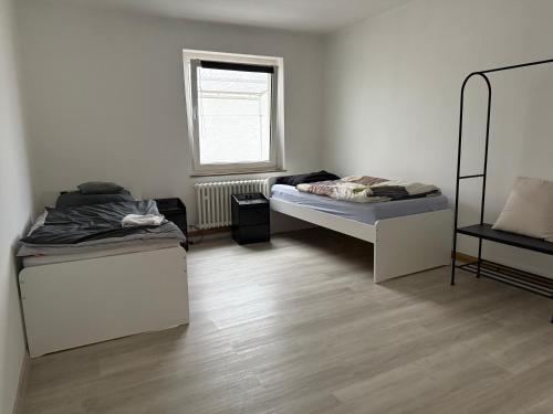 a room with two beds and a window at 3-Zimmer Ferienunterkunft in Bad Salzuflen