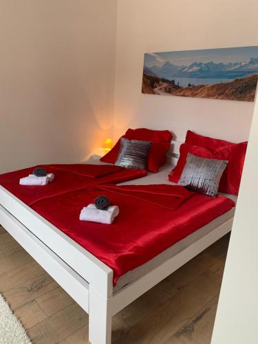 a white bed with red sheets and towels on it at Villa Julija with Private Pool in Bilišane