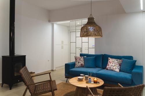 a living room with a blue couch and a table at Anemone House in Mesokhórion