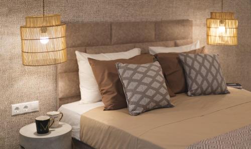 a bedroom with a bed with pillows and two lights at Anemone House in Mesokhórion