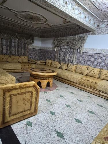 a living room with a couch and a table at Apparemment familiale villa 110 m2 jardin et piscine in MeknèsKatine