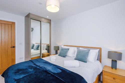 a bedroom with a large bed with blue pillows at Rock Mill - Superior Apartment with Private Patio in Stony Middleton