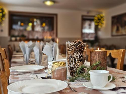 a table with white plates and candles on it at Willa Litworówka in Biały Dunajec