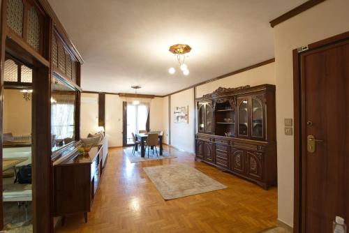a living room with a large wooden cabinet and a dining room at Alexandra Welcome Maxi Place in Kastoria