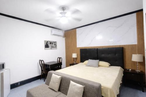 a bedroom with a large bed and a chair at Hotel Garcias Suites, Linares in Linares