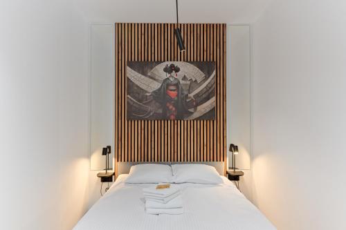 a bedroom with a white bed with a picture on the wall at Podmurna Zakątek in Toruń