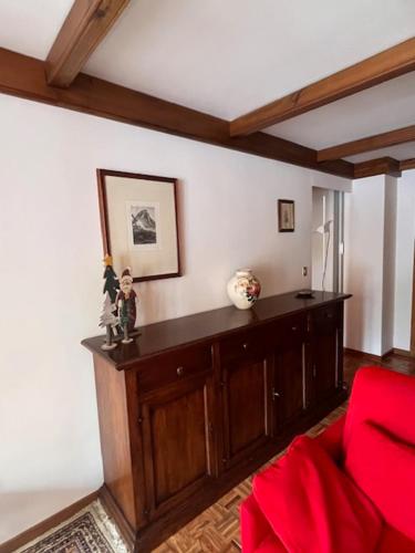 a living room with a red couch and a red chair at La casa di Marta, charme e relax in Breuil-Cervinia