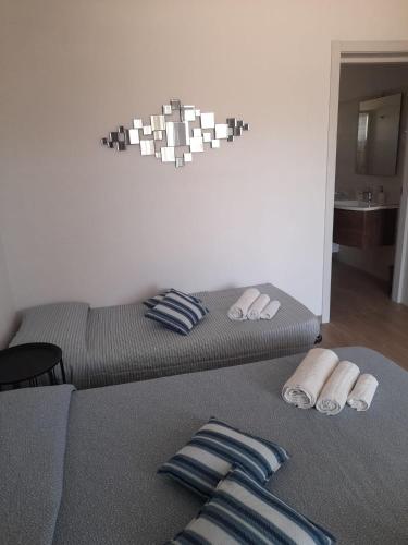 a bedroom with two beds with towels and a chandelier at B&B MARRELLA in Capilungo