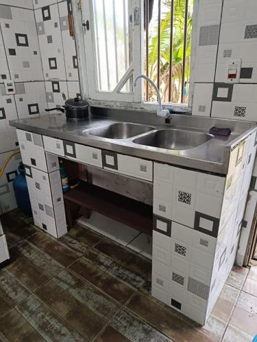 a kitchen with a sink and a window at Beira Mar in Tramandaí