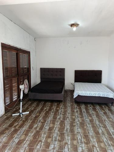 a room with two beds and a wooden floor at Beira Mar in Tramandaí