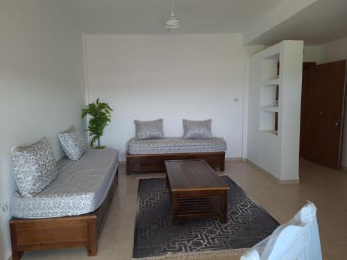 a living room with two couches and a coffee table at Appartements Mimosa in Tefeschoun
