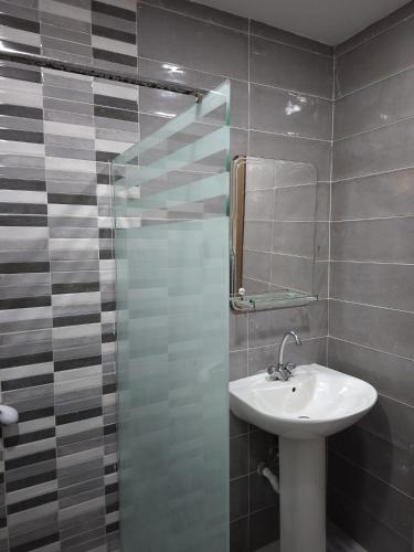 a bathroom with a sink and a shower with a mirror at Appartements Mimosa in Tefeschoun