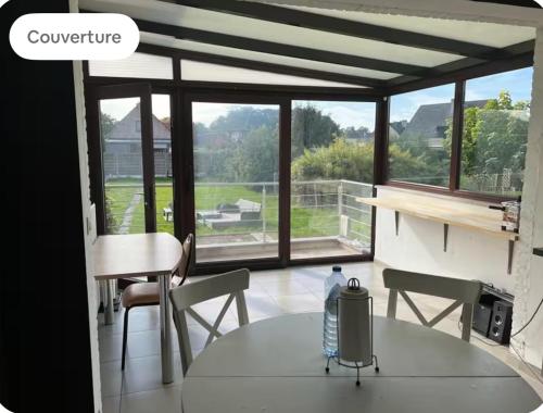 a room with a table and chairs and a window at Dar Fouad in Vilvoorde