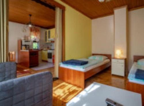 a room with a bed and a living room with a couch at Holiday House Briški in Delnice