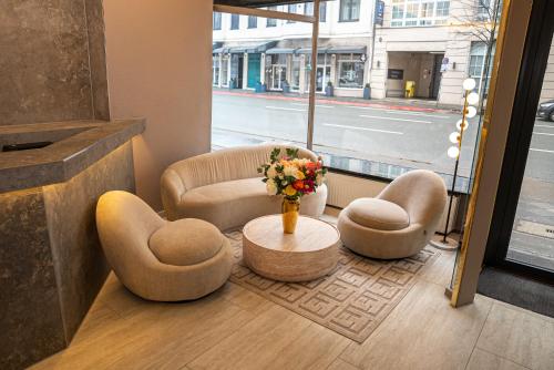 a lobby with two chairs and a table with a vase of flowers at Adrett Hotel Königsallee in Düsseldorf