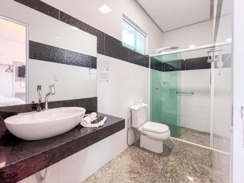a bathroom with a sink and a toilet and a glass shower at Pousada Barreirinhas in Barreirinhas