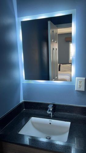 a bathroom with a sink and a mirror at Suburban Studios Charlotte - Ballantyne in Charlotte